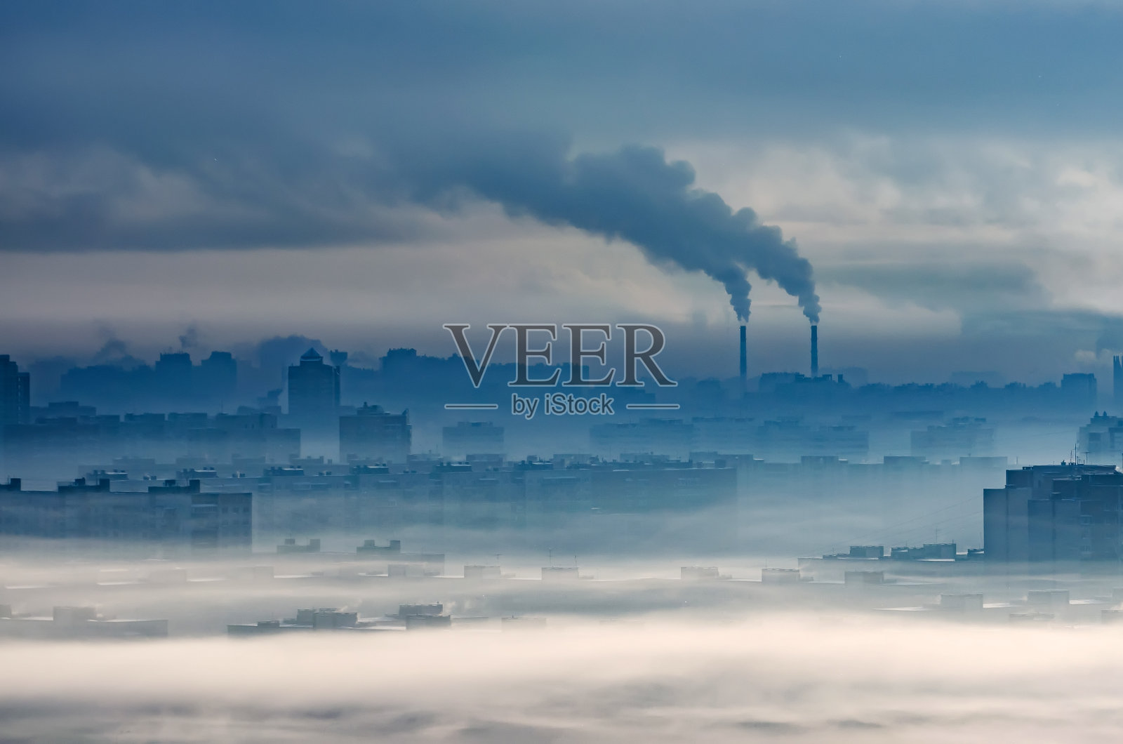 城市工业景观，住宅建筑被烟和雾霾所掩埋，化工厂向大气中排放烟雾照片摄影图片