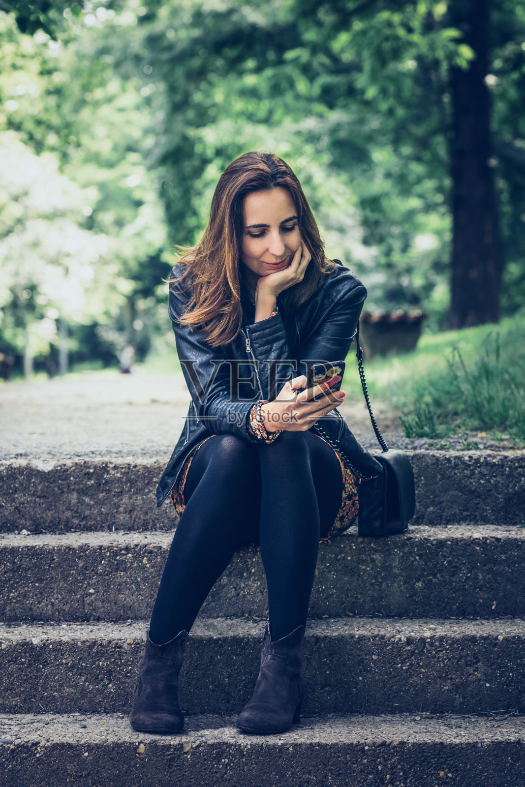 在公园里用手机的女人照片摄影图片