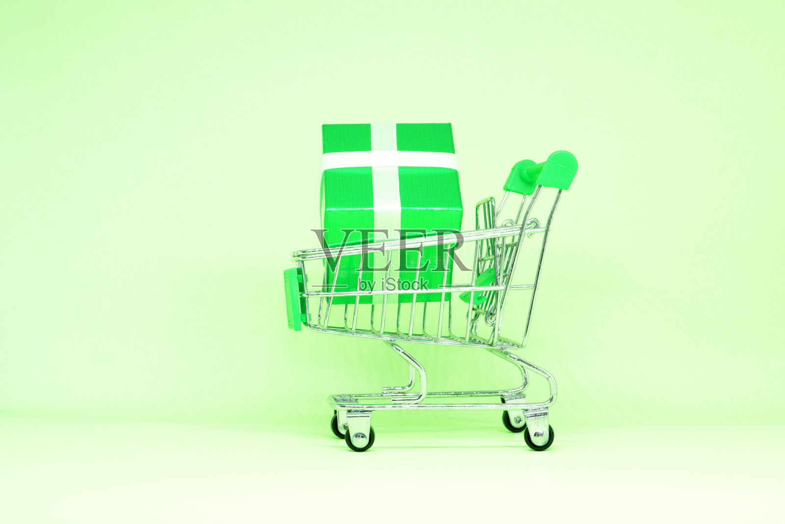 绿色礼盒在购物车上的绿色背景-爱，情人节，生日，或特别感谢购物-营销广告标志或横幅业务照片摄影图片