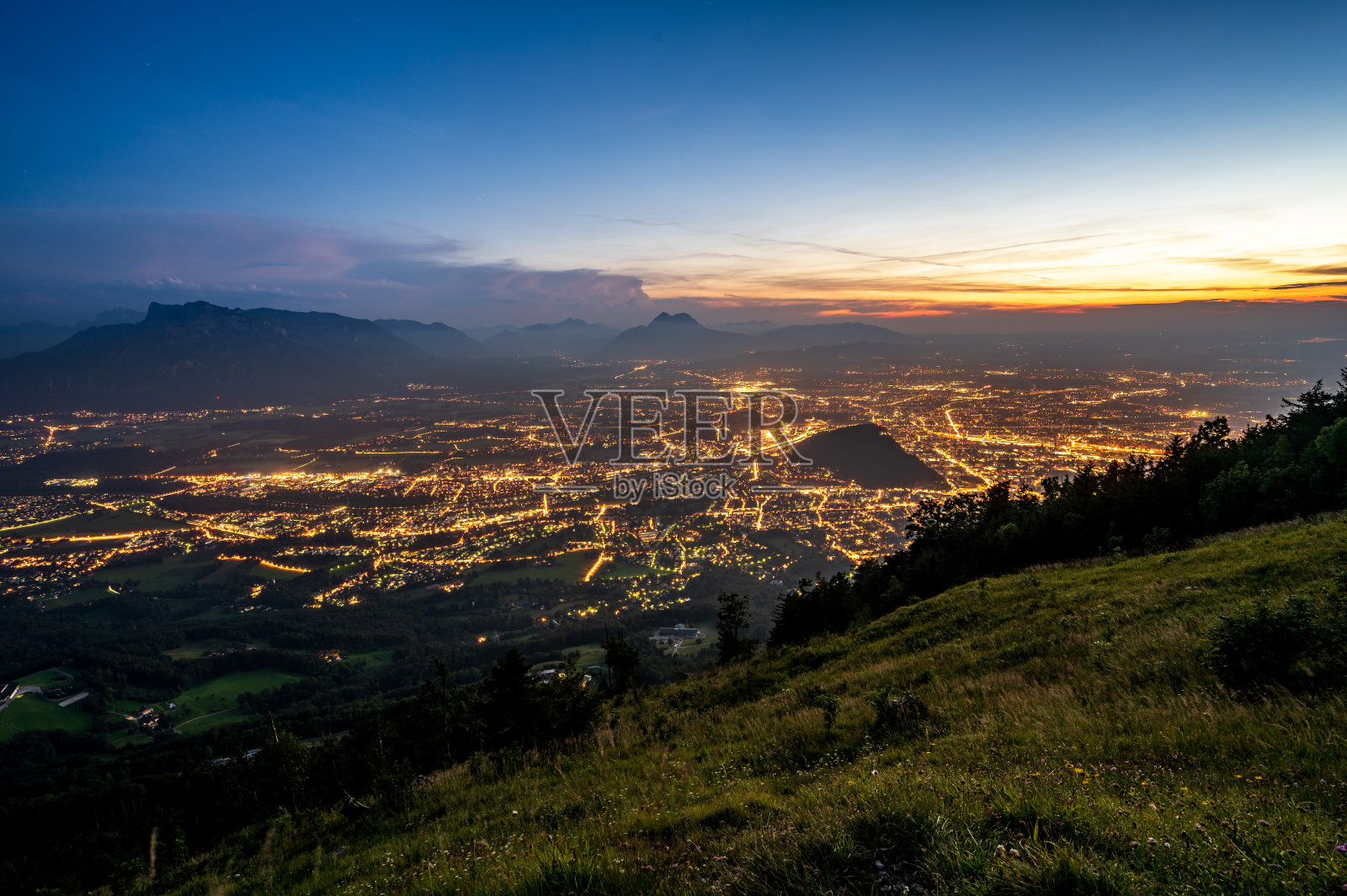 日落后，从盖斯堡山俯瞰灯火辉煌的萨尔茨堡照片摄影图片