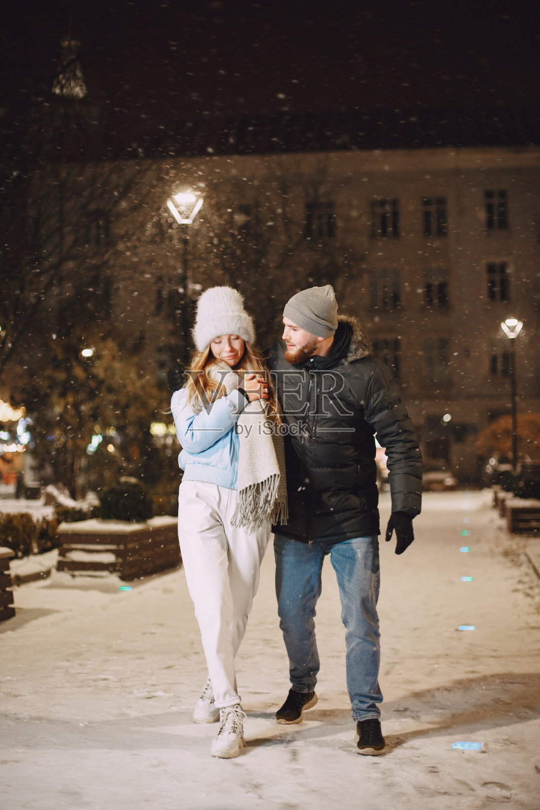 年轻夫妇在夜晚的街道在圣诞节时间照片摄影图片