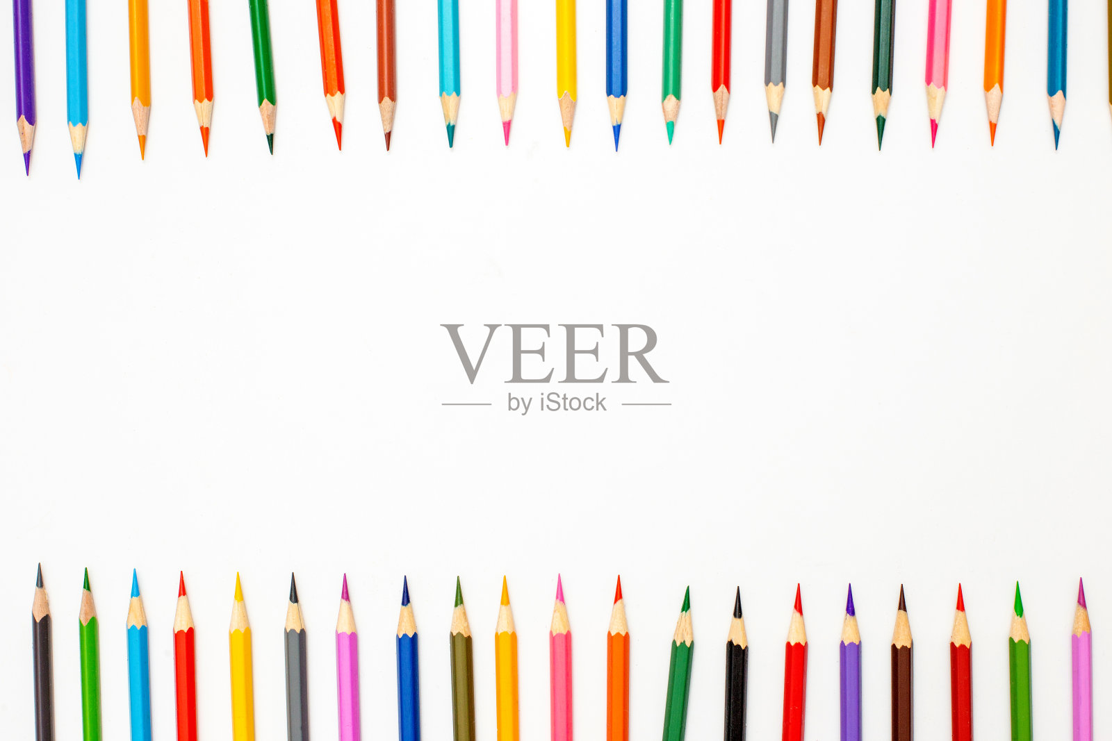 从一排多色铅笔与顶部在白色背景的框架。照片摄影图片