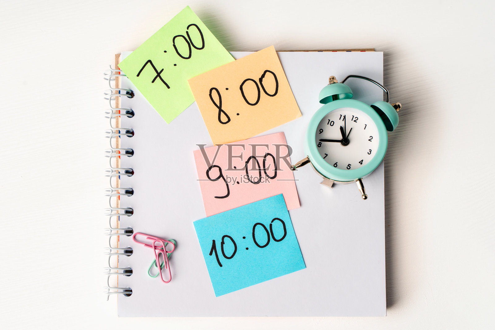 彩色笔记与时间在桌面上用记事本，闹钟。副本的空间。计划一天的概念，时间表。照片摄影图片