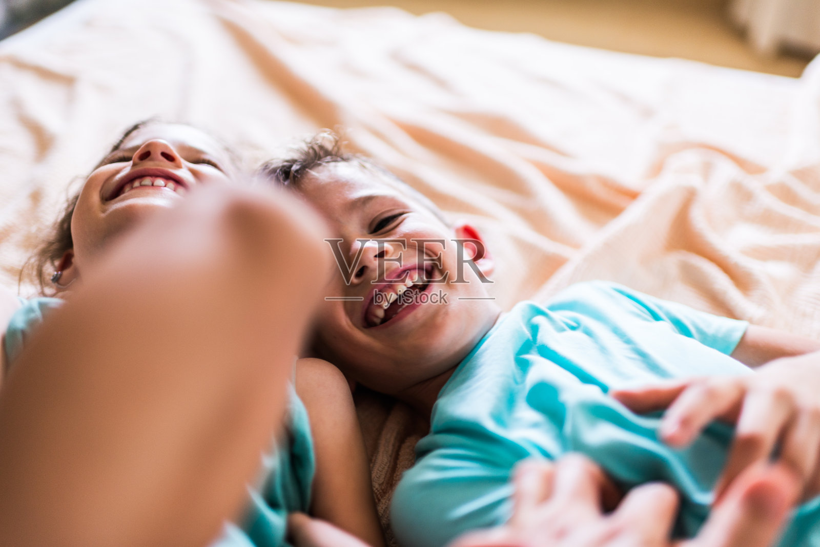 漂亮的孩子们在床上玩耍照片摄影图片