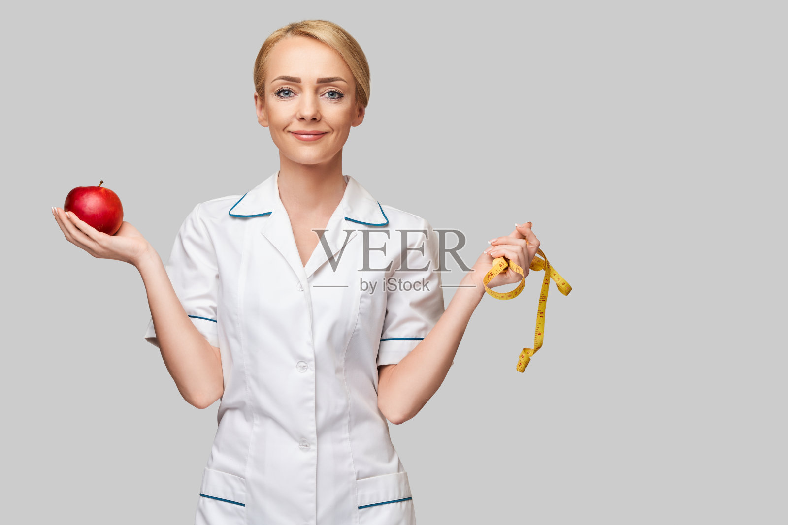 营养学家医生健康生活方式概念-拿着有机红苹果和量尺照片摄影图片