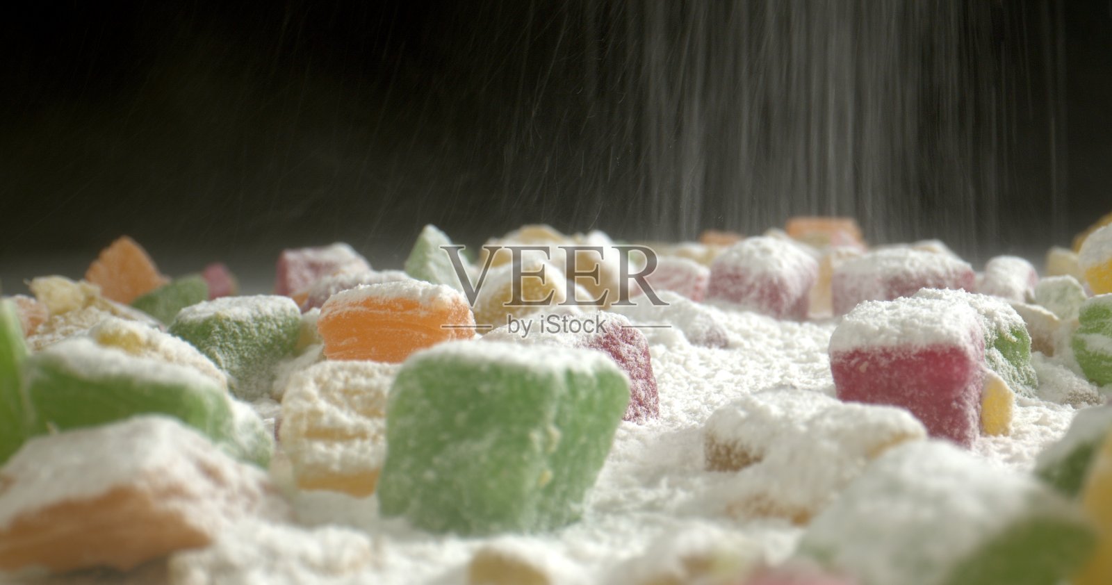 在混合干果上撒上糖粉。苹果干，芒果，菲约，杏干，西梅。五彩糖果美味概念。关闭了。照片摄影图片