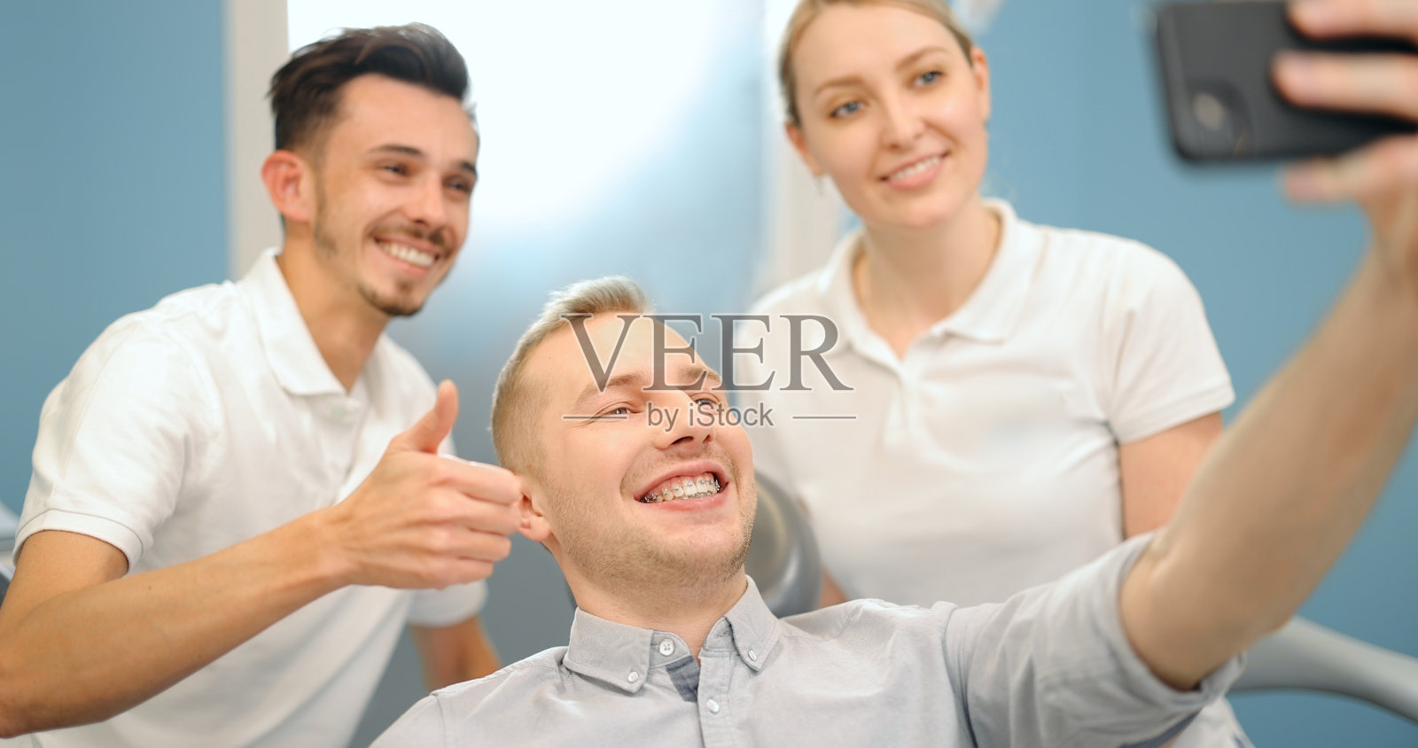 在牙科诊所看牙医的快乐病人照片摄影图片