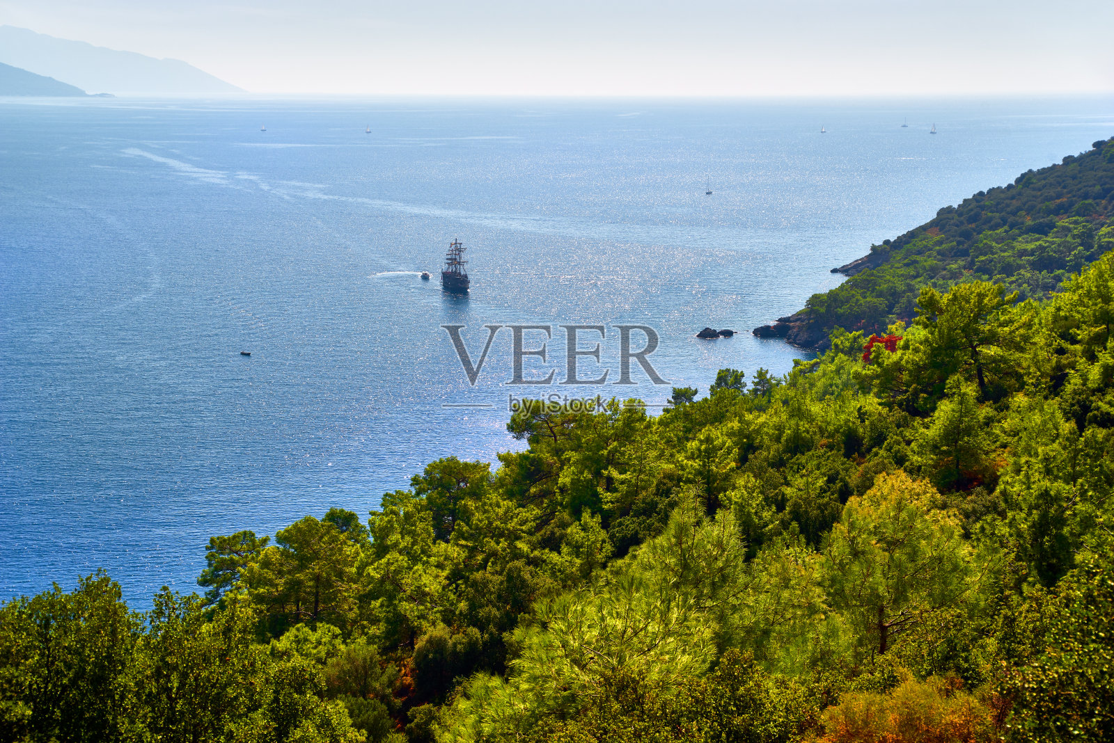 从山上眺望蔚蓝的地中海，山坡和海湾长满了松树绿林照片摄影图片