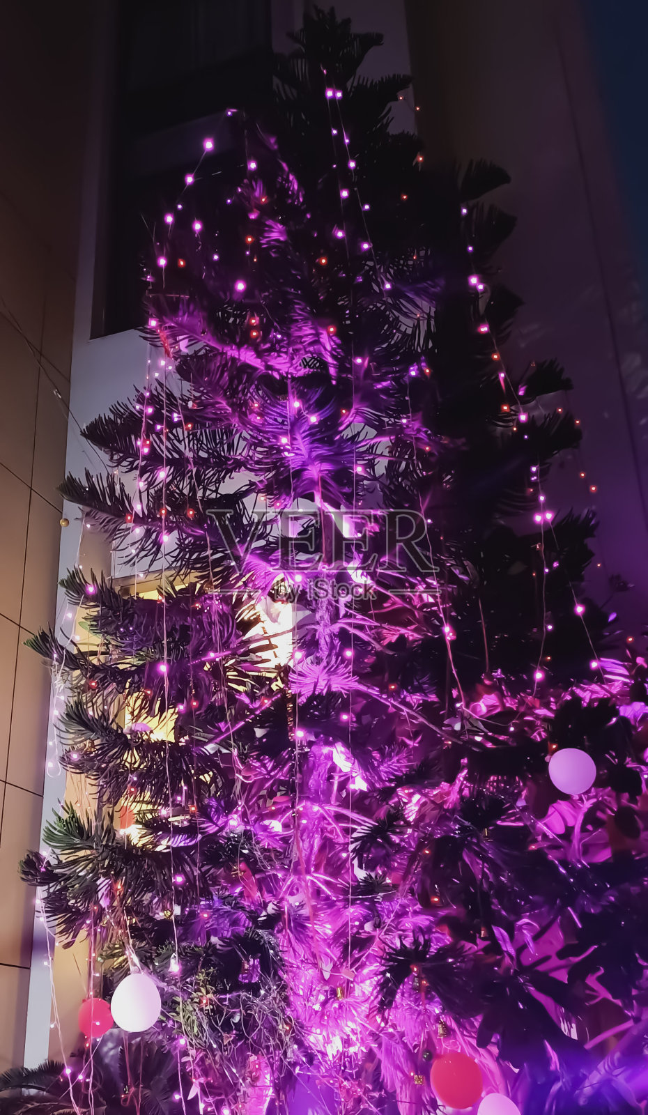 在美丽的平安夜，用不同的东西装饰圣诞树照片摄影图片