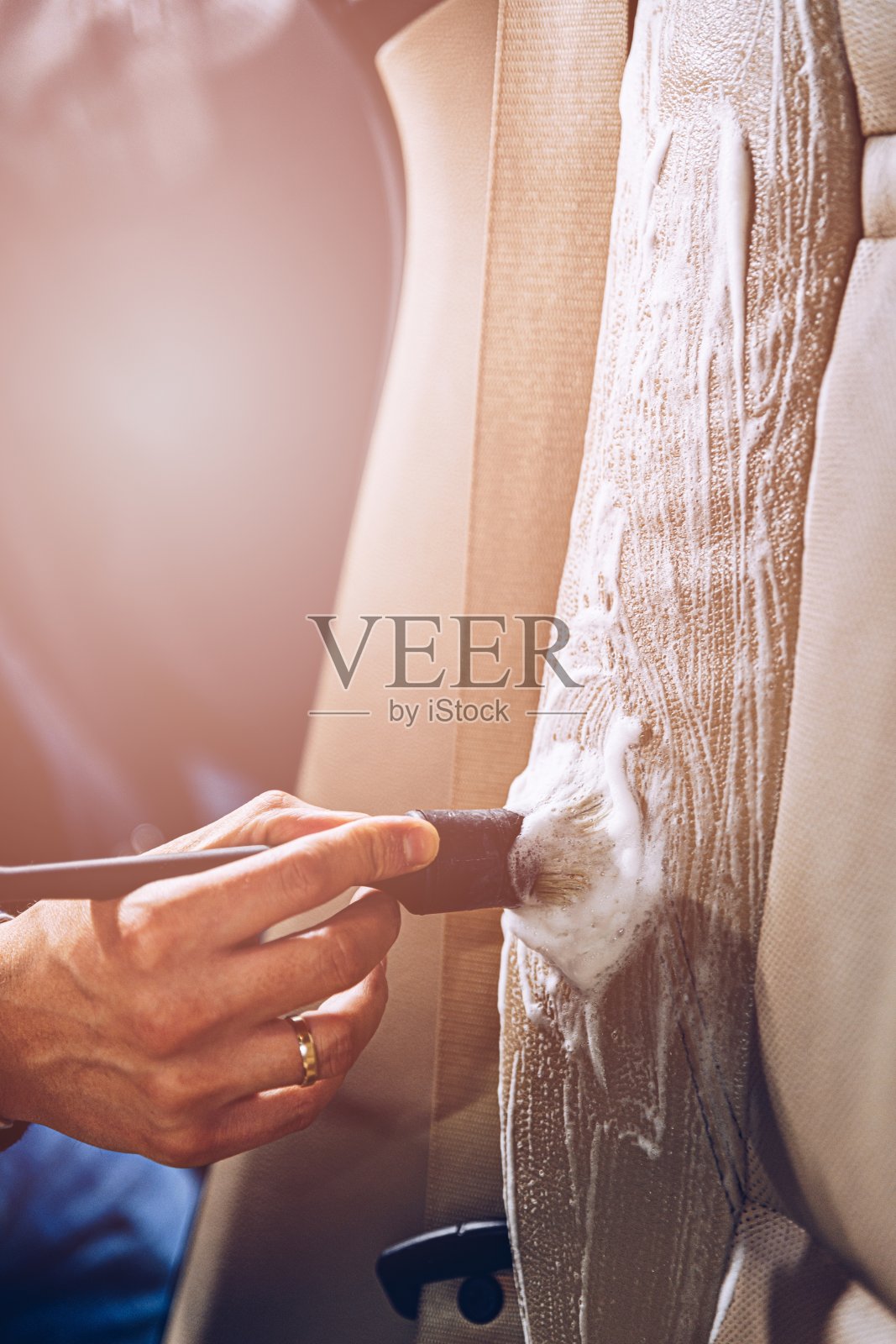 洗车工人用刷子清洗汽车皮车。照片摄影图片