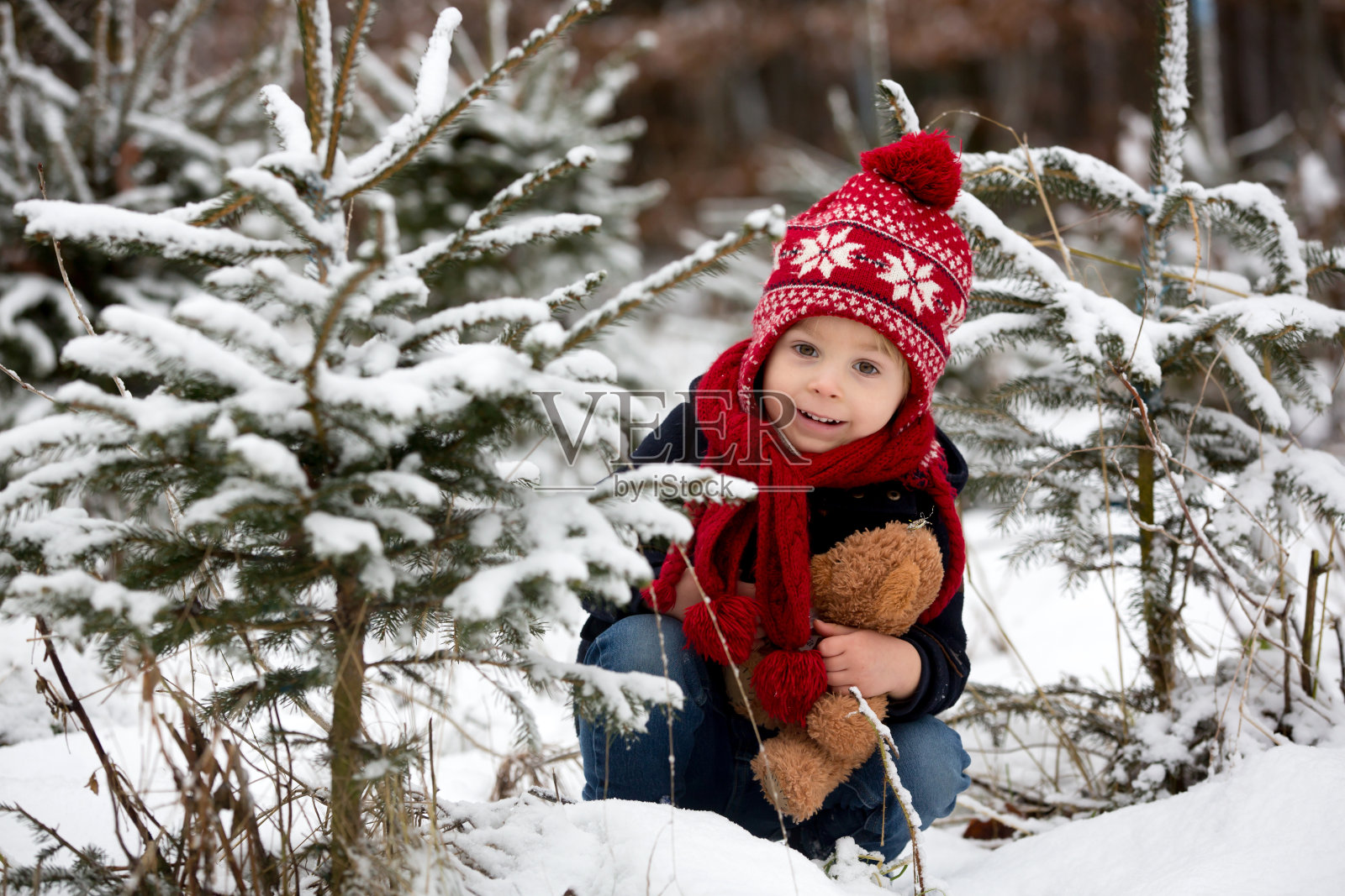 公园里可爱的小孩，站在圣诞树之间照片摄影图片