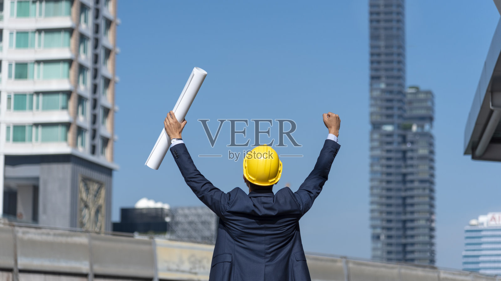 安全服信托团队的建筑工程师在施工现场手持黄白安全安全帽安全设备。土木建筑工程师安全帽保护头。工程概念照片摄影图片