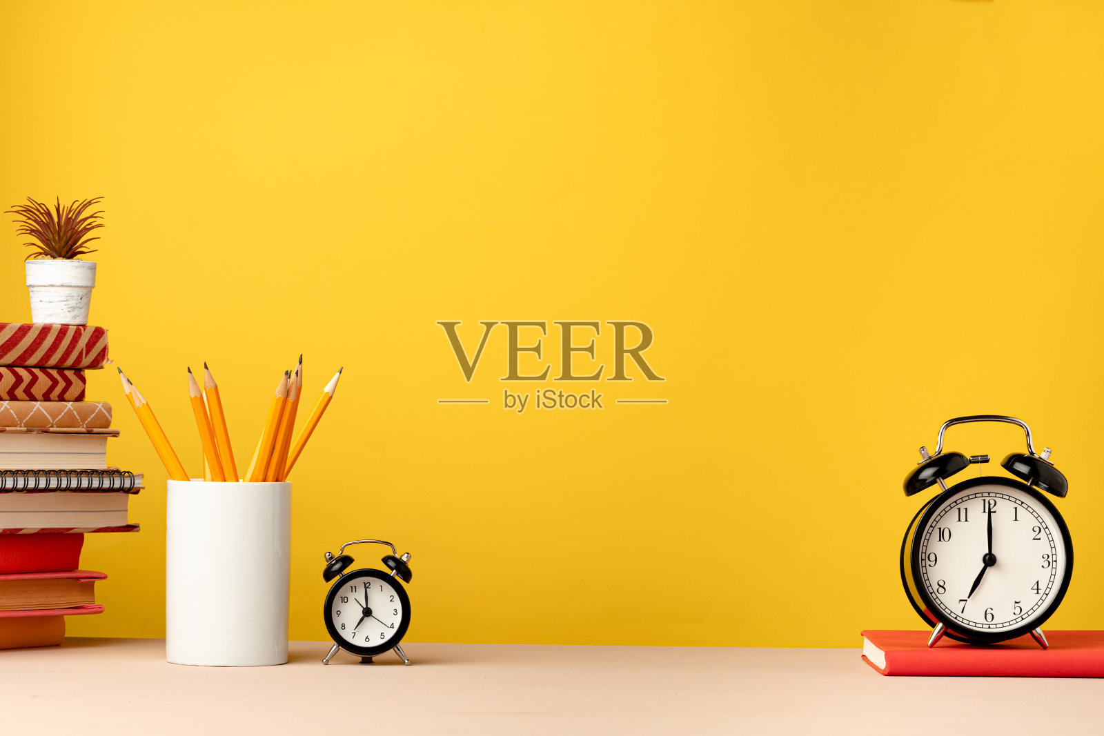 桌上黄色背景的铅笔和记事本照片摄影图片