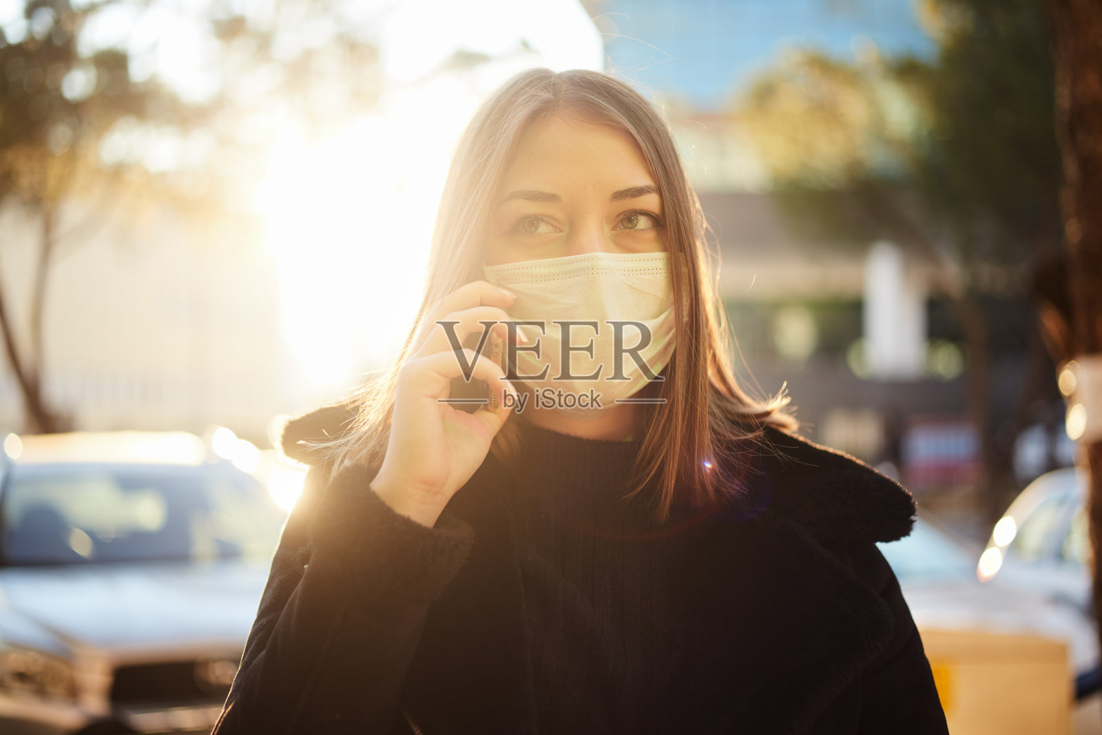 年轻女孩用防护面罩打电话照片摄影图片