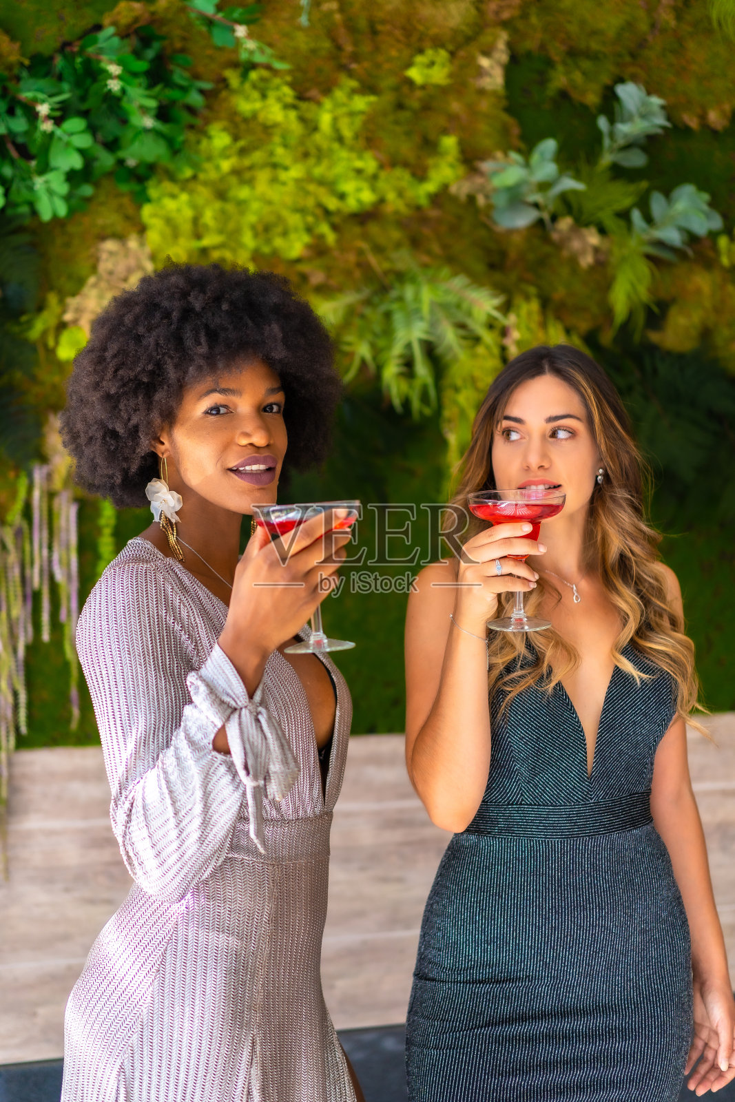 两个穿着礼服的朋友在酒店的派对上喝鸡尾酒，生活方式。魅力生活，专属派对照片摄影图片