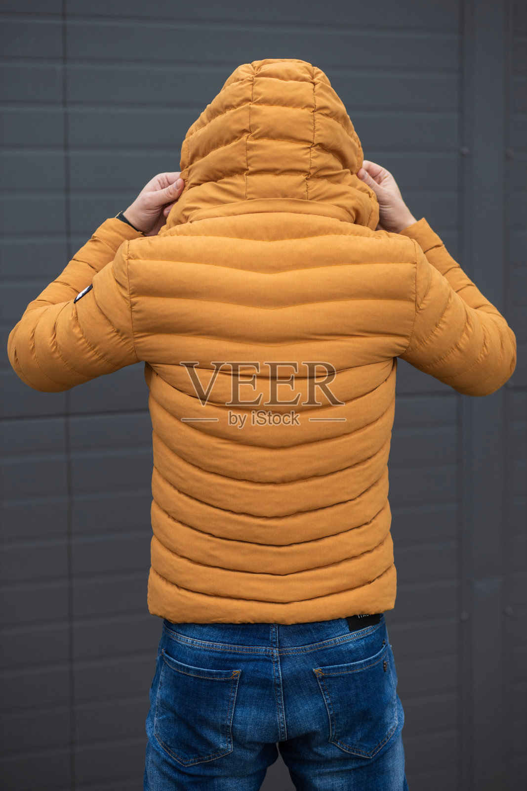 年轻英俊的小伙子穿着暖和的针织衣服，映衬着黑色的墙壁照片摄影图片