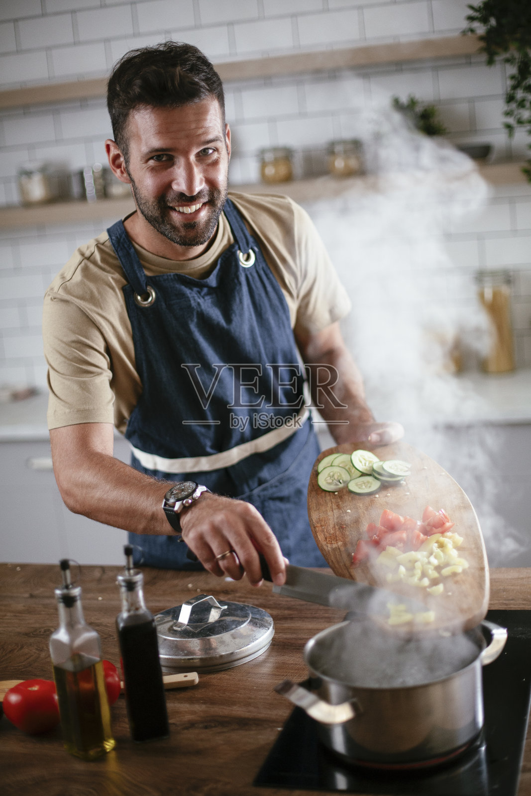 快乐的男人在家准备美味的食物。照片摄影图片