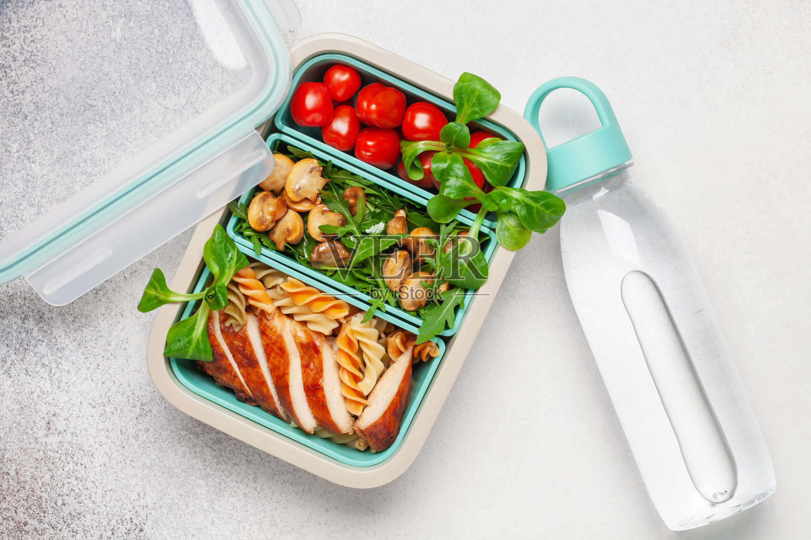 烤鸡胸肉，意大利面，芝麻菜，蘑菇和新鲜的羊肉沙拉在午餐盒。俯视图照片摄影图片