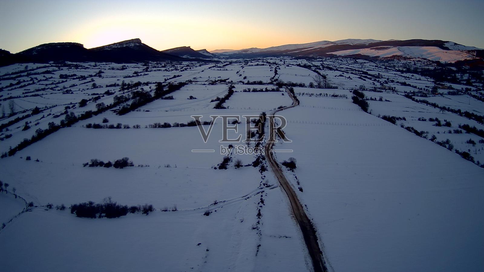 冬天，布尔戈斯北部雪山上的日落与它的光的游戏。照片摄影图片