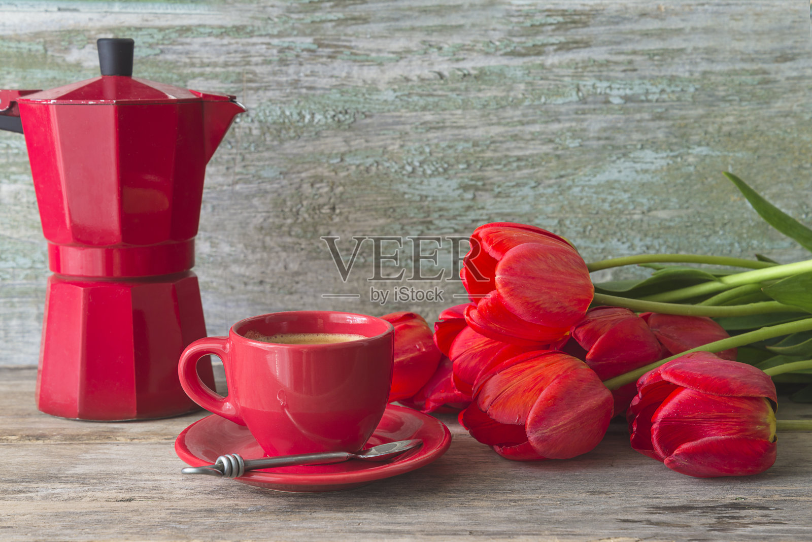 红色的咖啡杯，咖啡机和一束红色郁金香在旧的木头背景照片摄影图片