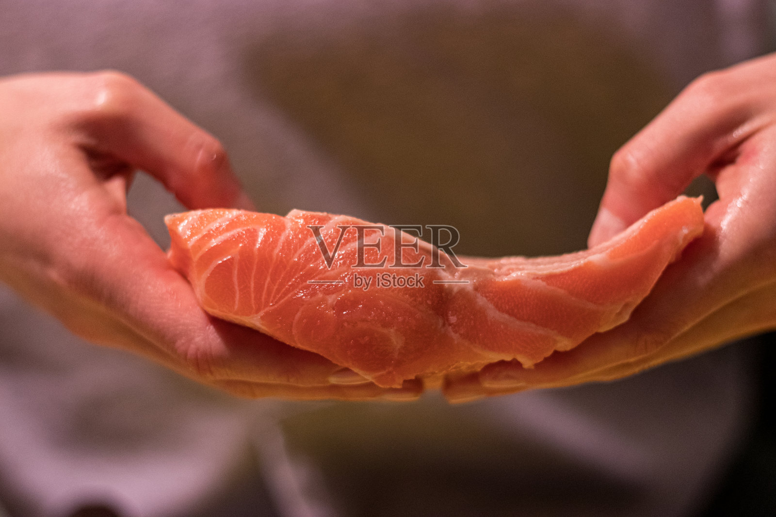 手握三文鱼排照片摄影图片