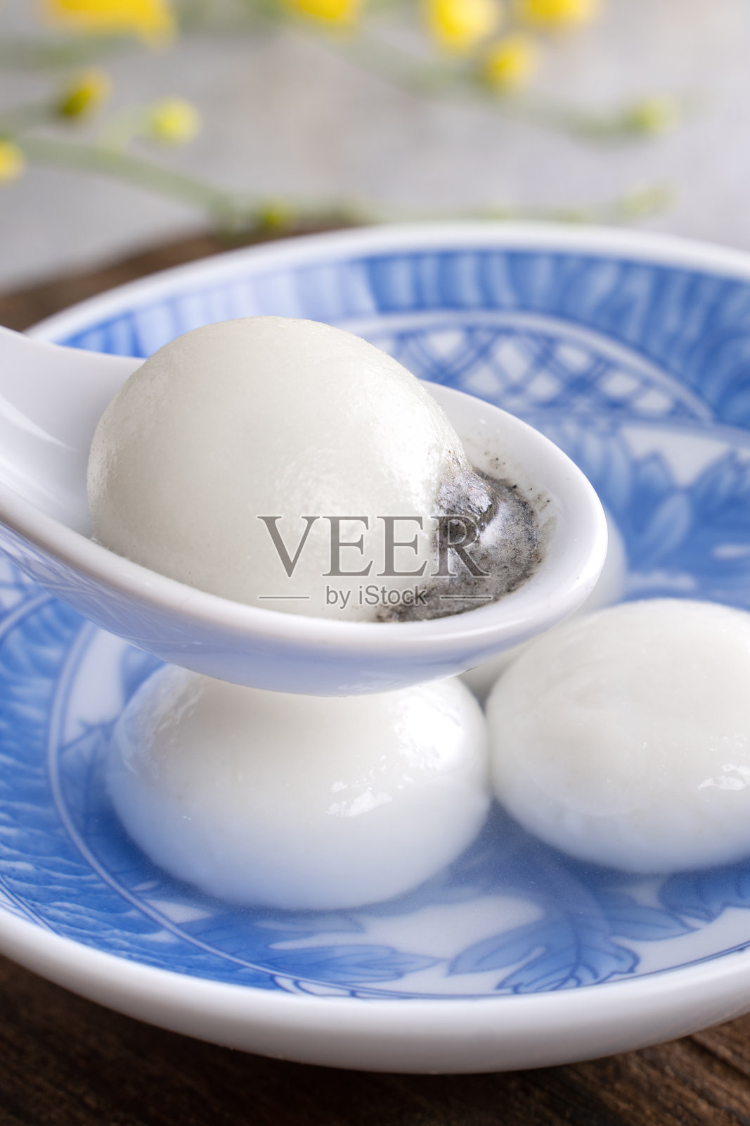 特写的元宵汤圆在一个碗在灰色的桌子上，食物为中国元宵节。照片摄影图片