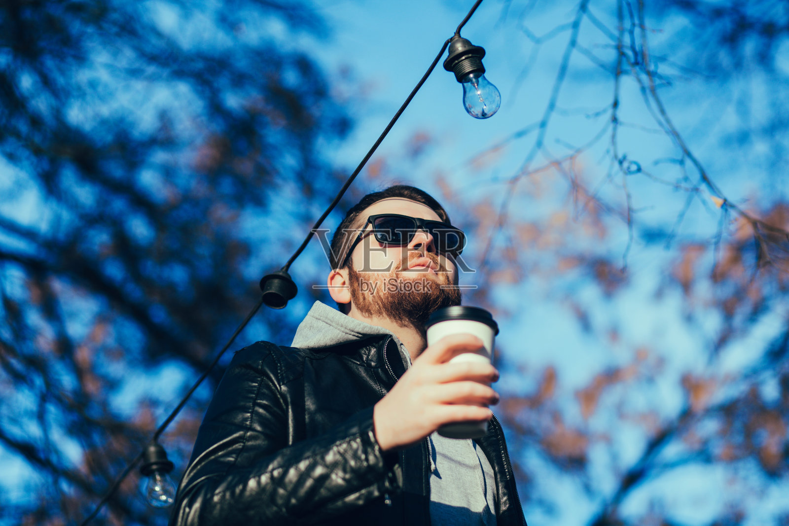 穿皮夹克喝咖啡的男人照片摄影图片