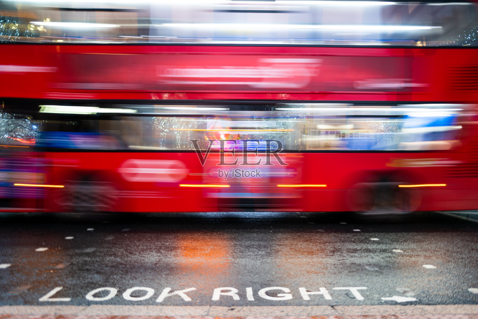 在城市中超速行驶的红色伦敦巴士的模糊运动照片摄影图片