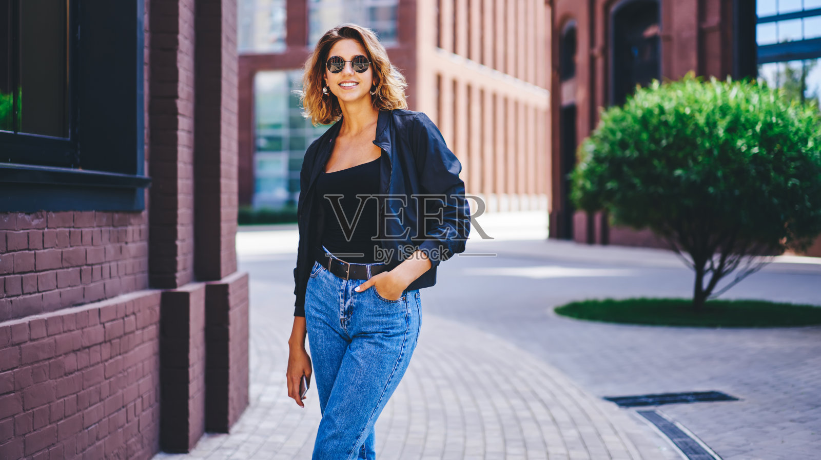 在街道上的建筑物附近微笑的女人照片摄影图片