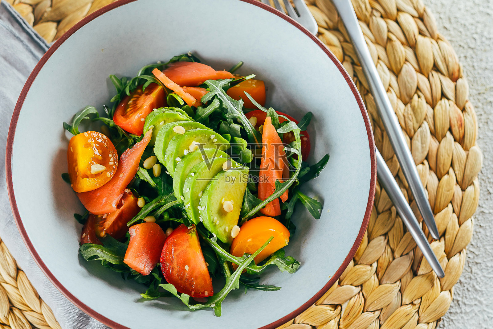 健康的素食沙拉碗，有三文鱼，番茄，鳄梨，芝麻菜。美味均衡的食物概念。照片摄影图片