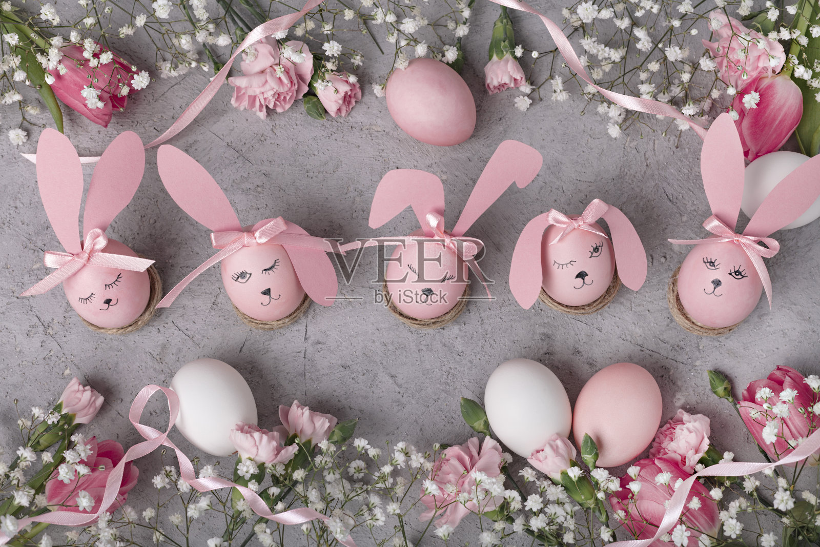 复活节快乐!粉红色的鸡蛋和粉红色的花——郁金香和康乃馨。有选择性的重点。照片摄影图片