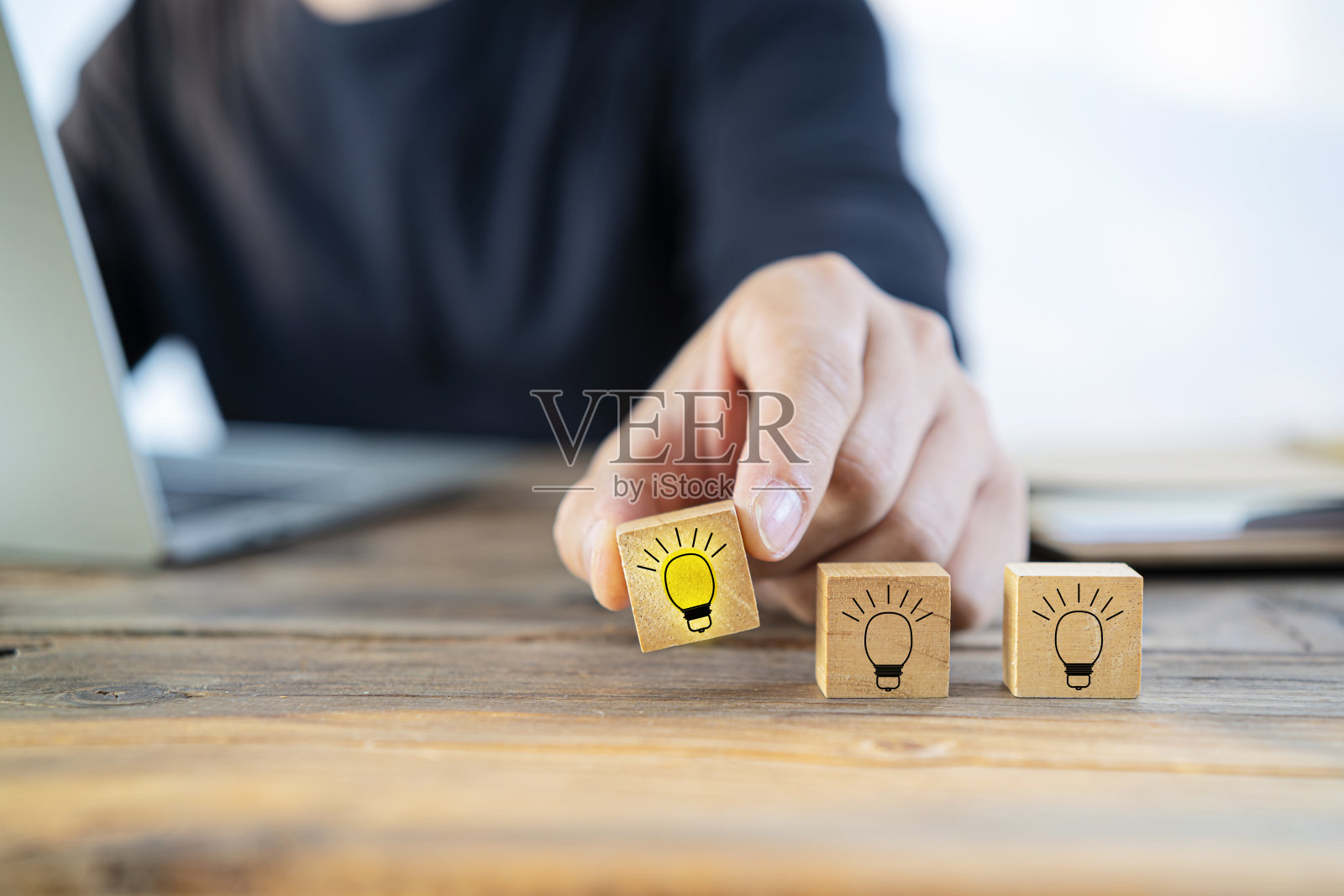 近距离的商人安排一个小木块与一个灯泡的绘图照片摄影图片