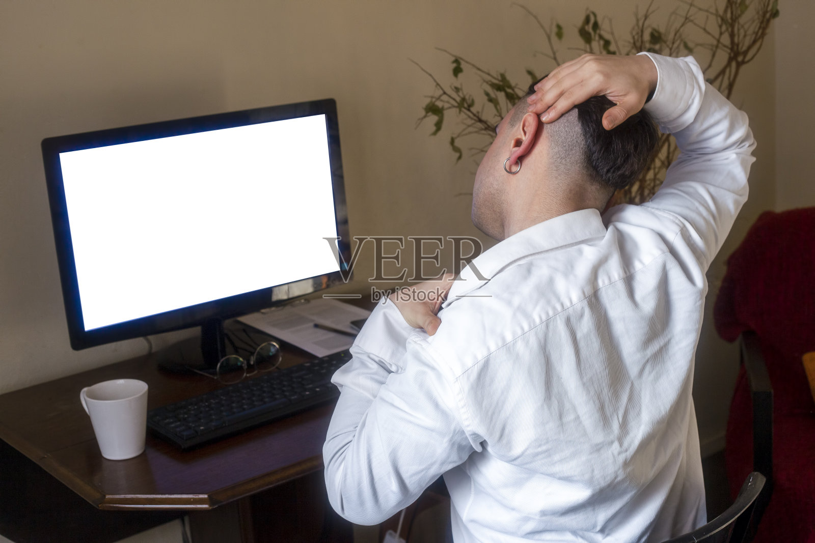 疲惫的男人在家里用电脑工作时脖子痛照片摄影图片