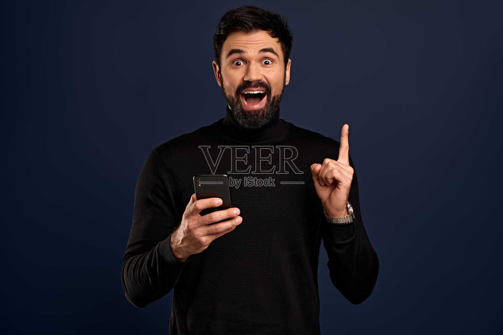 有魅力的男人在时尚高领毛衣，举起食指在eureka手势微笑快乐，找到了答案，给有趣的建议，快乐终于解决问题，太平洋蓝色背景照片摄影图片