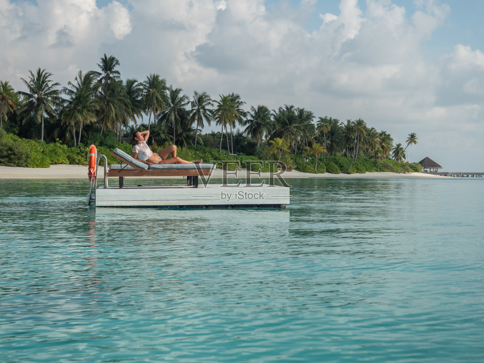 在热带泻湖上的木筏上放松的女人照片摄影图片