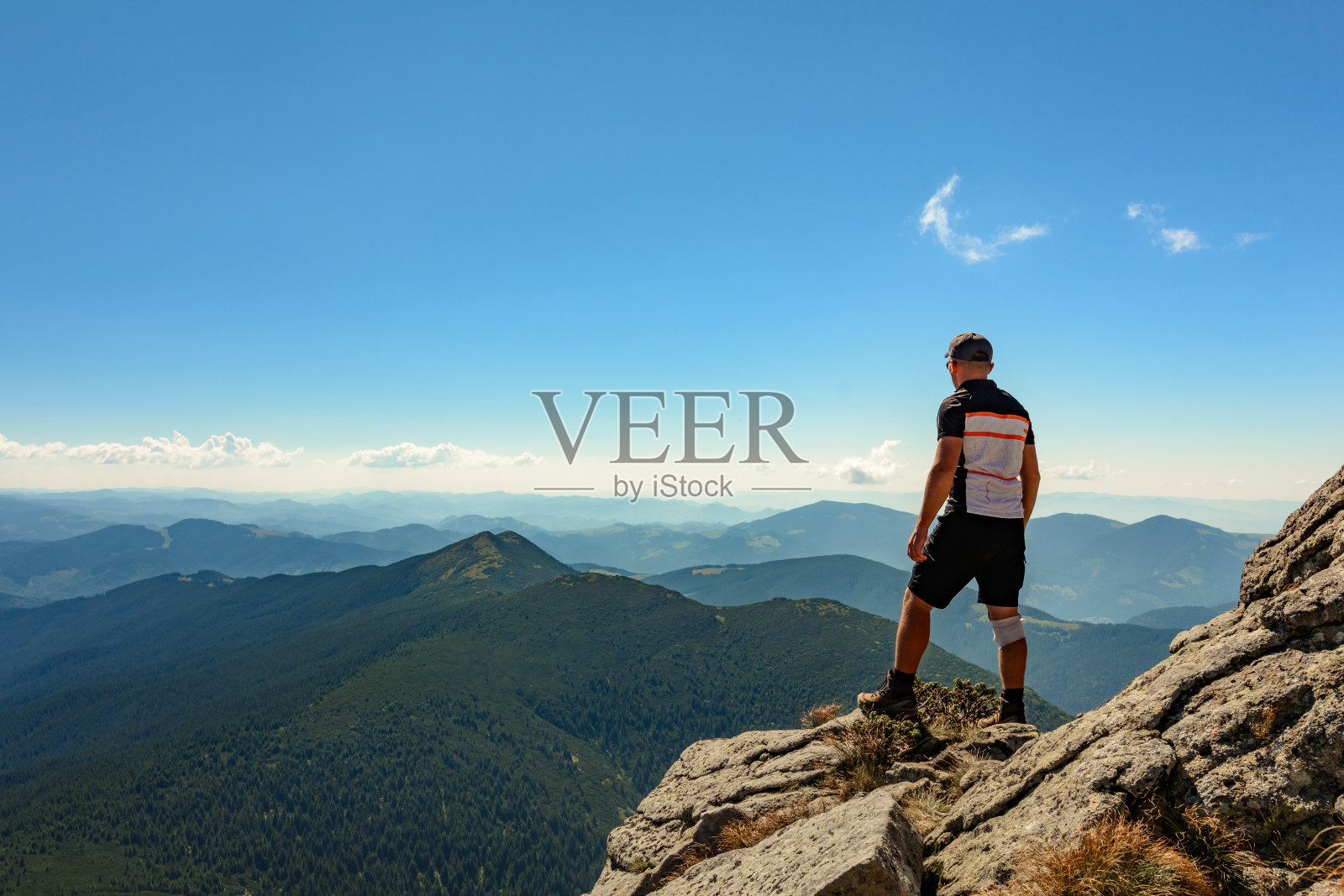 一名游客站在一个巨大的石头山顶上，这是乌克兰喀尔巴阡山脉的一个多岩石的山峰。照片摄影图片