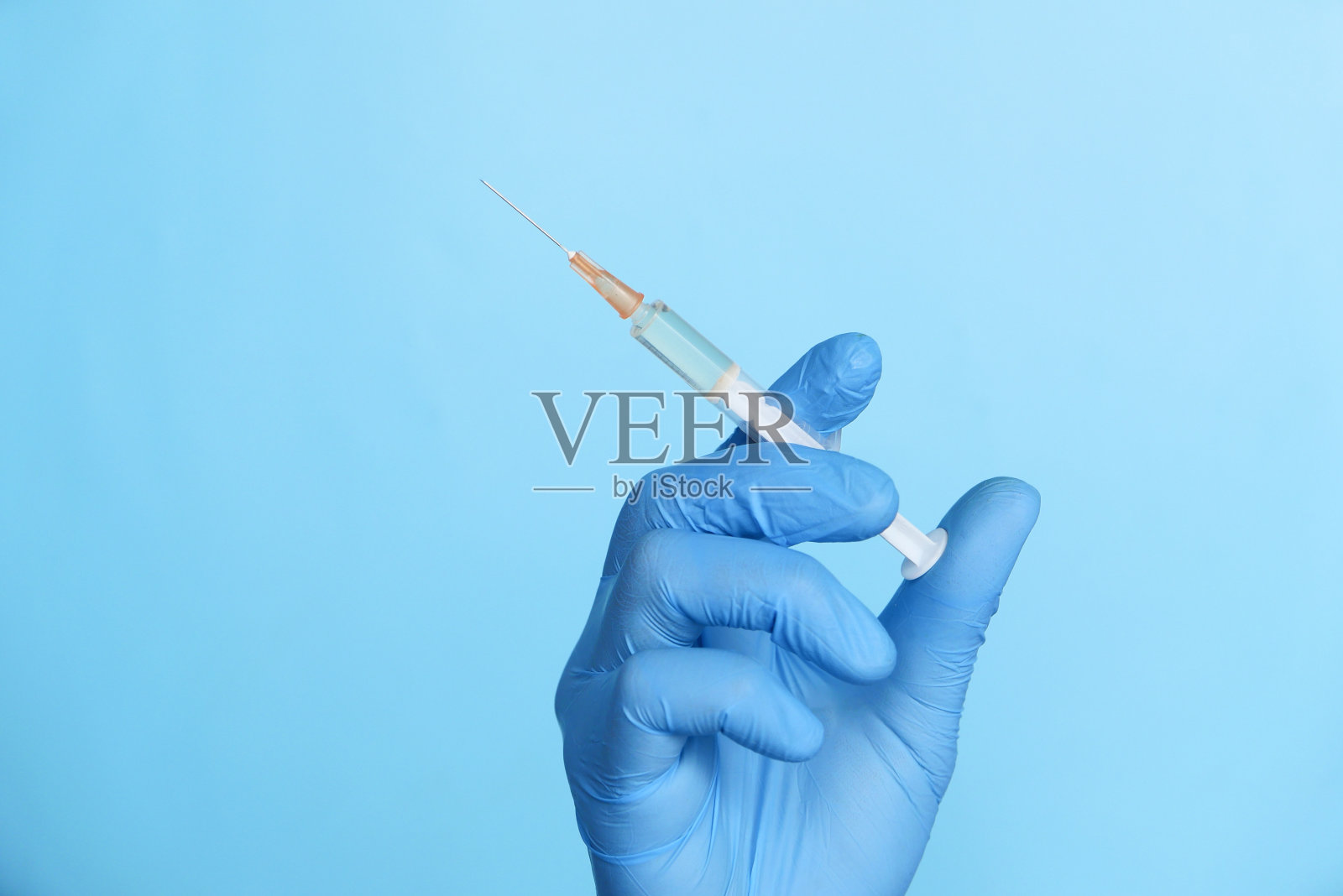 医生手拿医用手套拿注射器。照片摄影图片