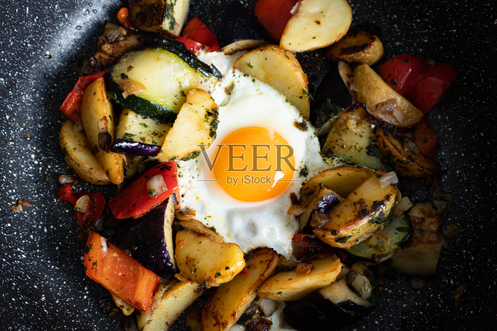 煎蛋配烤蔬菜，香肠。中间是明亮的圆形蛋黄。照片摄影图片