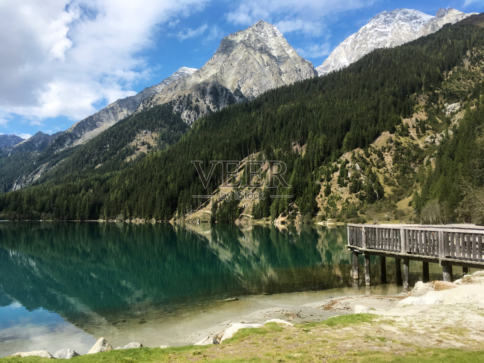 风景优美的意大利山湖与深蓝色的水和山与一些雪的背景照片摄影图片