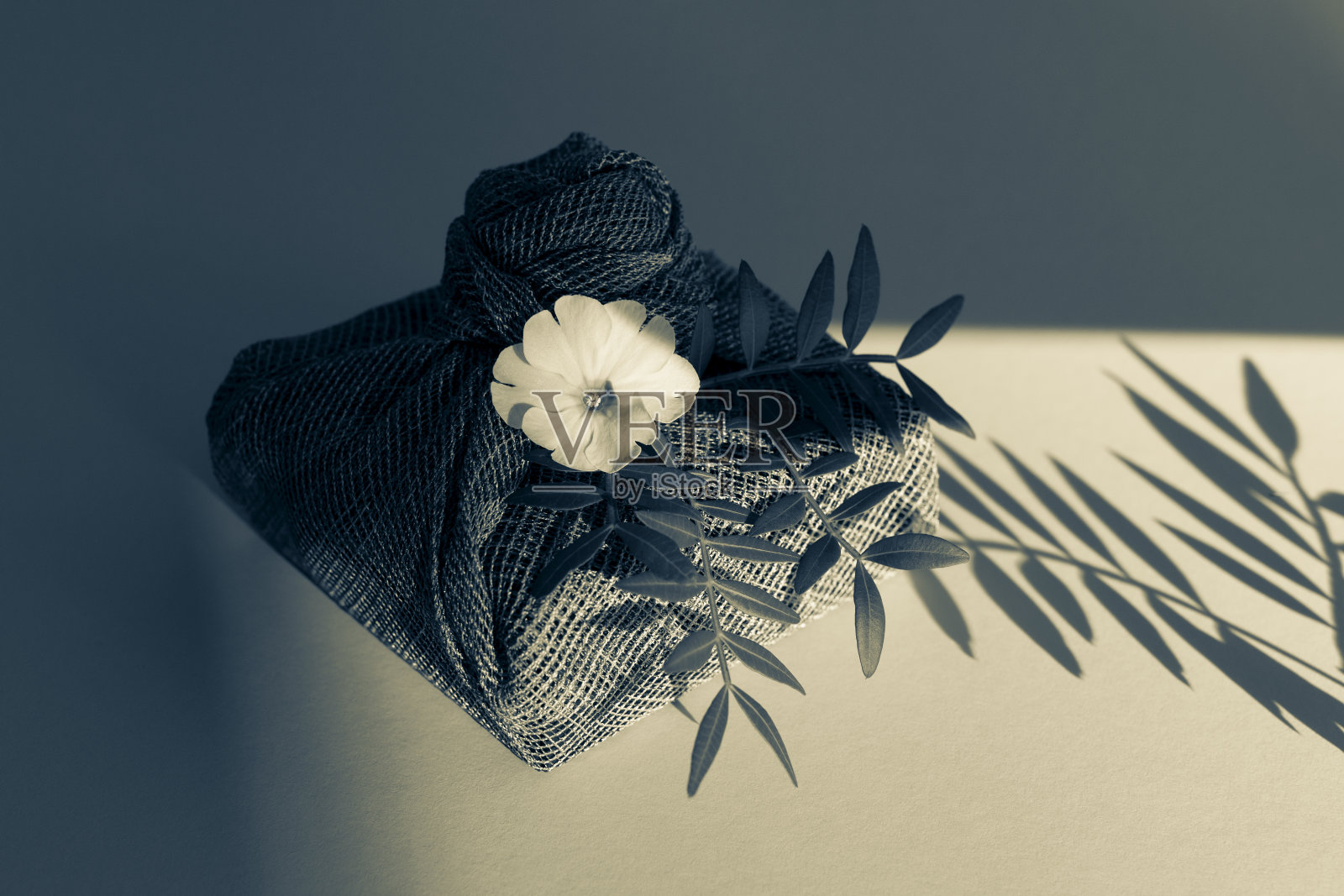 Furoshiki礼物。环保织物，可重复使用的礼品包装与鲜花和树叶。照片摄影图片