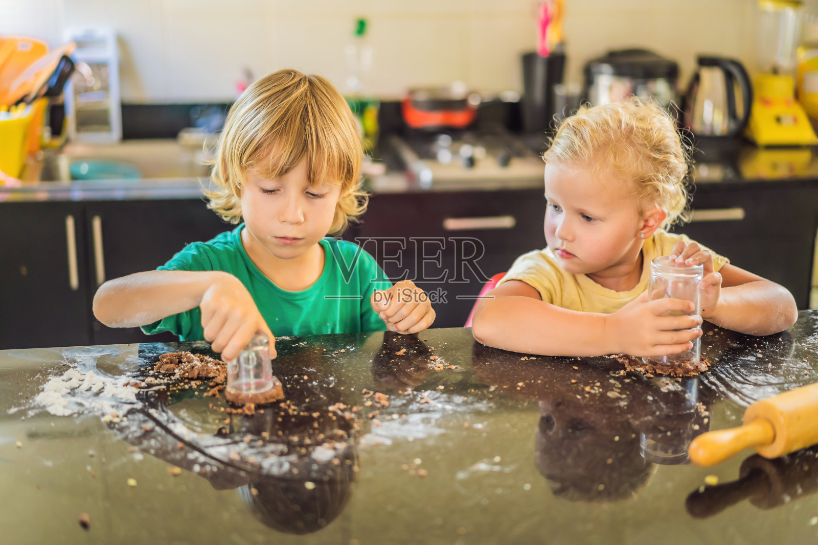 两个孩子，一个男孩和一个女孩用面团做饼干照片摄影图片
