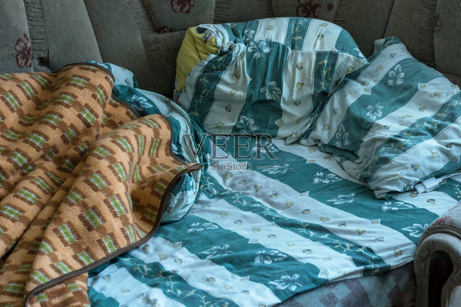 看到有凹陷的毯子垫和床单躺在床上。照片摄影图片