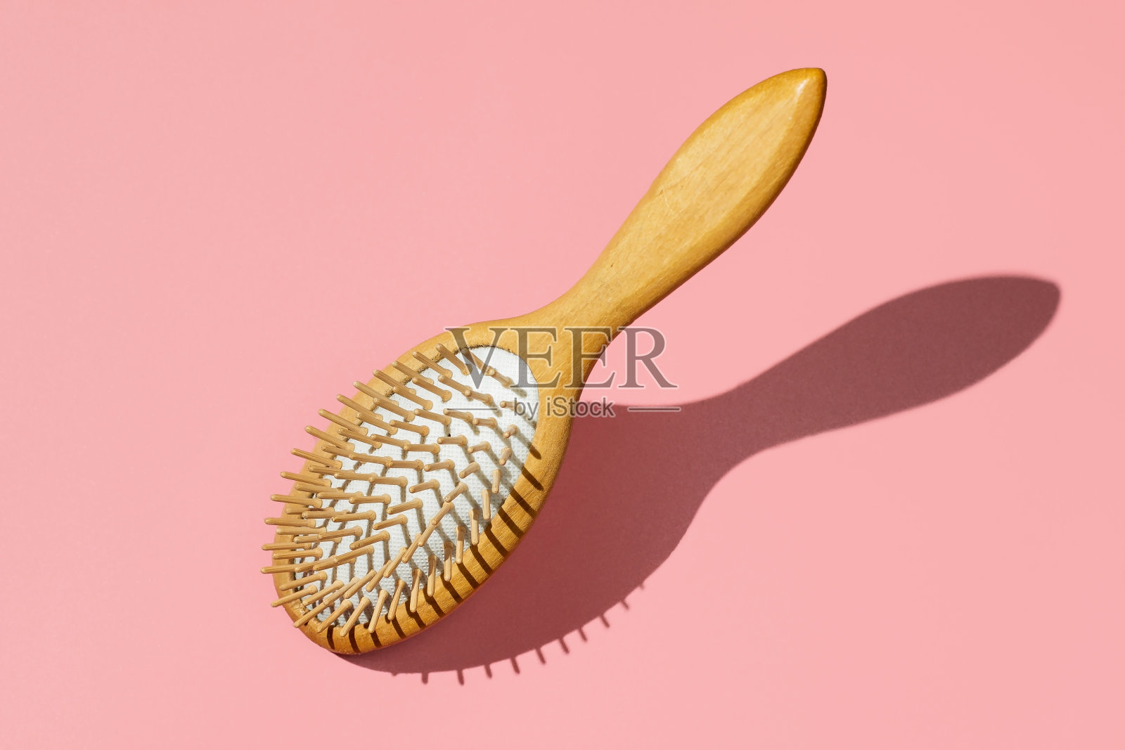 高耸的木梳子上的粉色背景最小概念，俯视图照片摄影图片