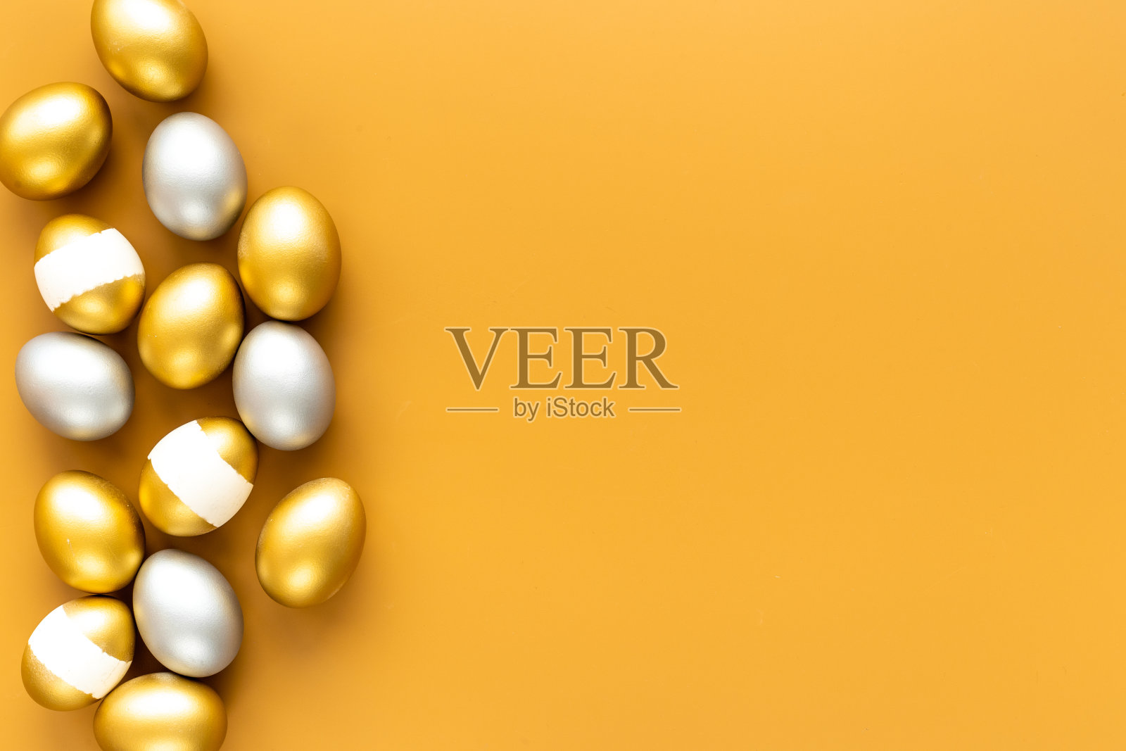 复活节快乐卡上有金彩蛋和银彩蛋，俯视照片摄影图片