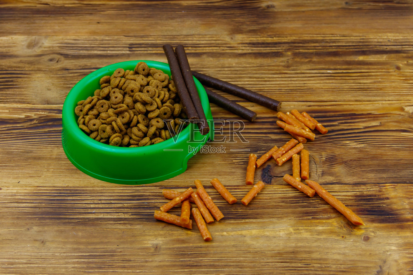 狗的美味食物和饲料在绿色塑料碗在木背景。狗护理的概念照片摄影图片