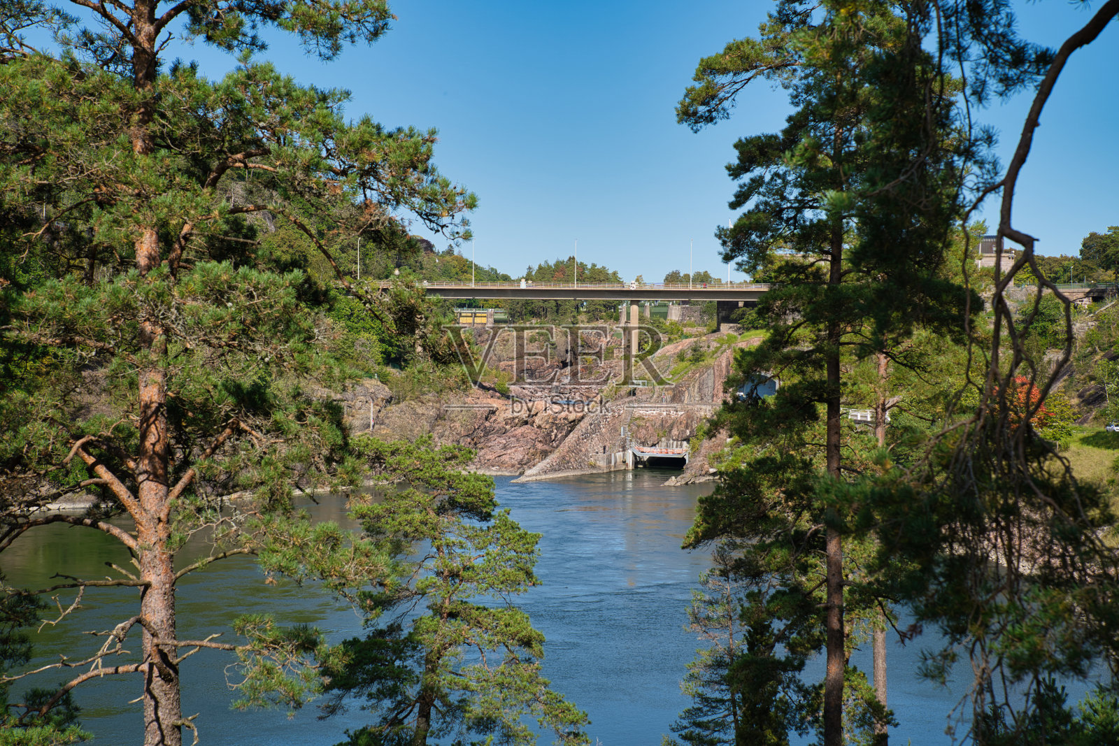 湖上有一扇水门，从森林中可以看到照片摄影图片