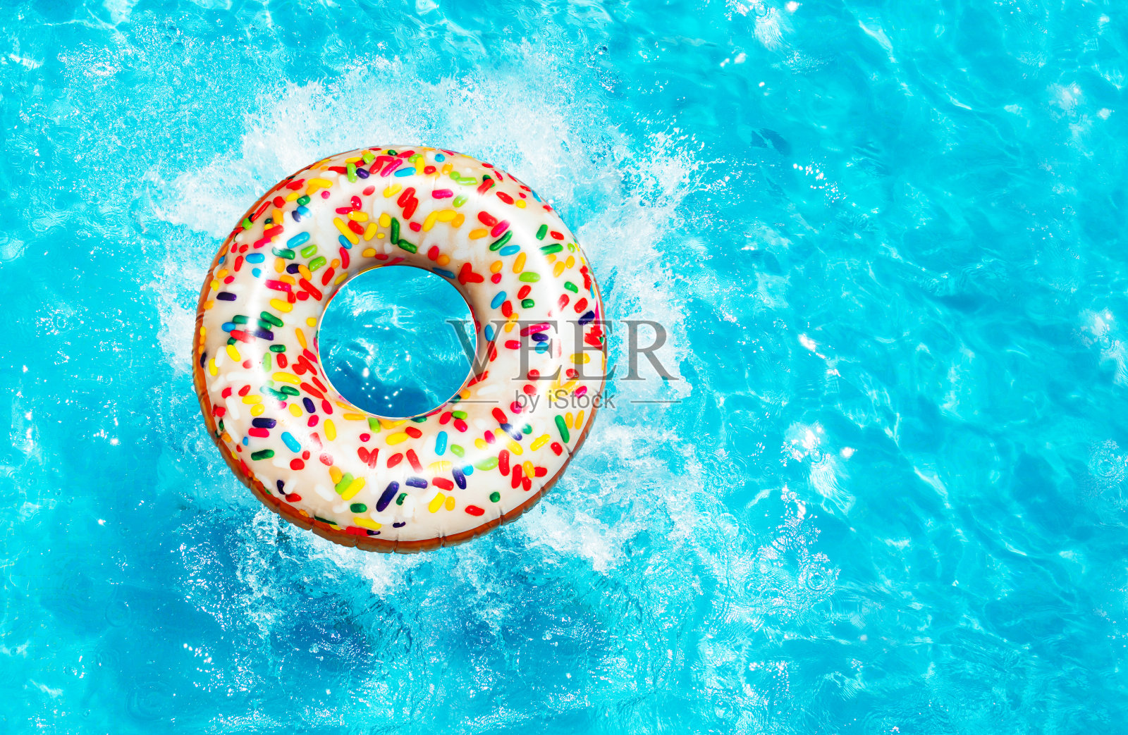 充气甜甜圈浮标飞溅在游泳池俯视图照片摄影图片