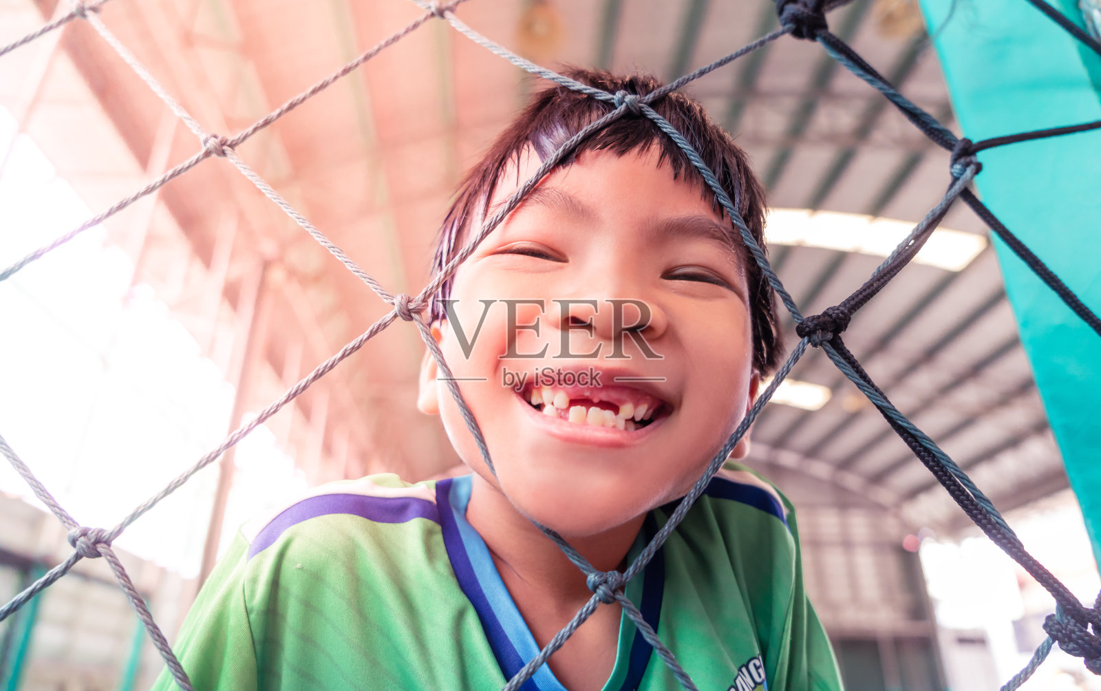 快乐的亚洲孩子带着微笑在足球训练场上为孩子们运动娱乐的生活理念。照片摄影图片