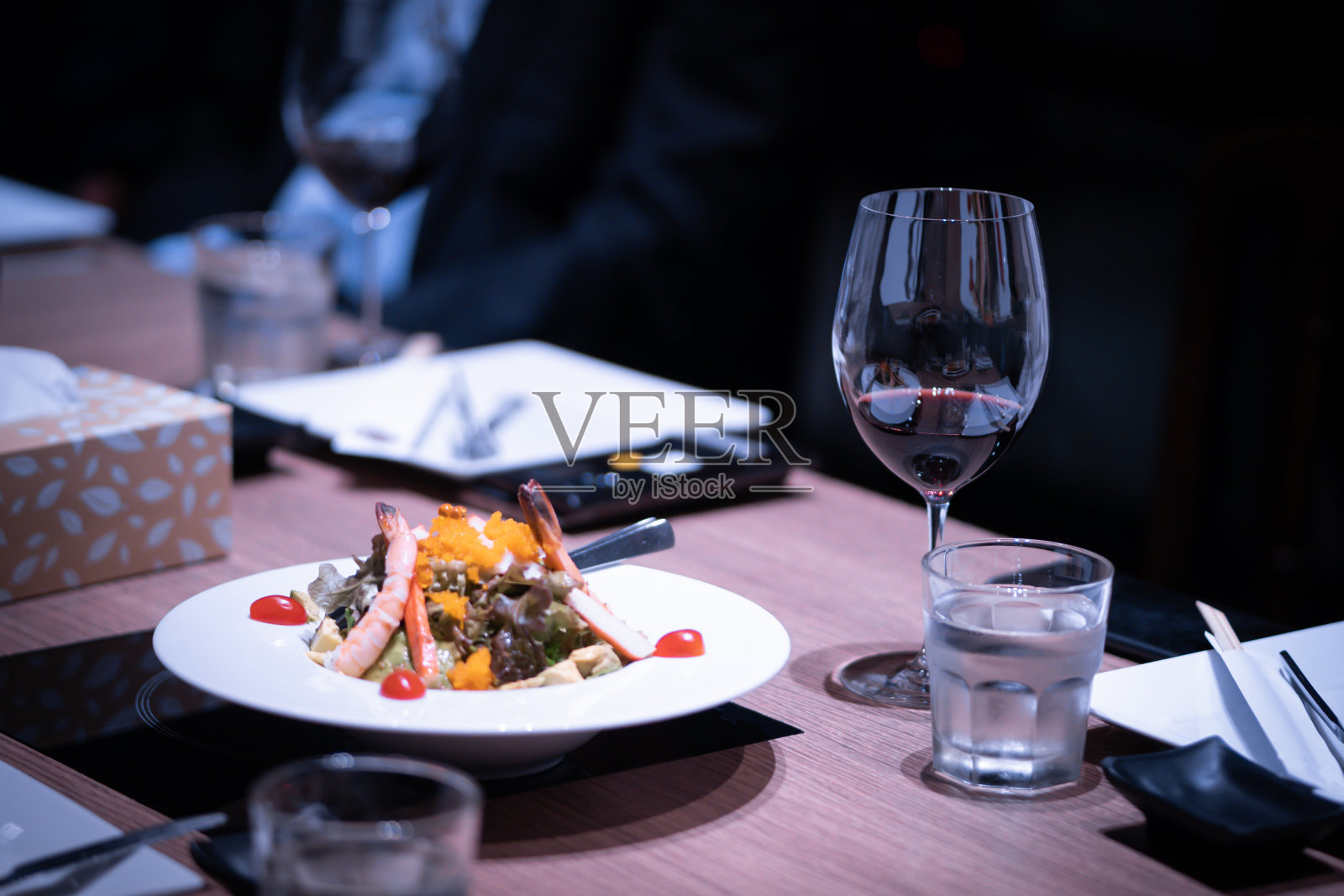 在一家精致的餐厅里，晚餐被放在餐桌上照片摄影图片