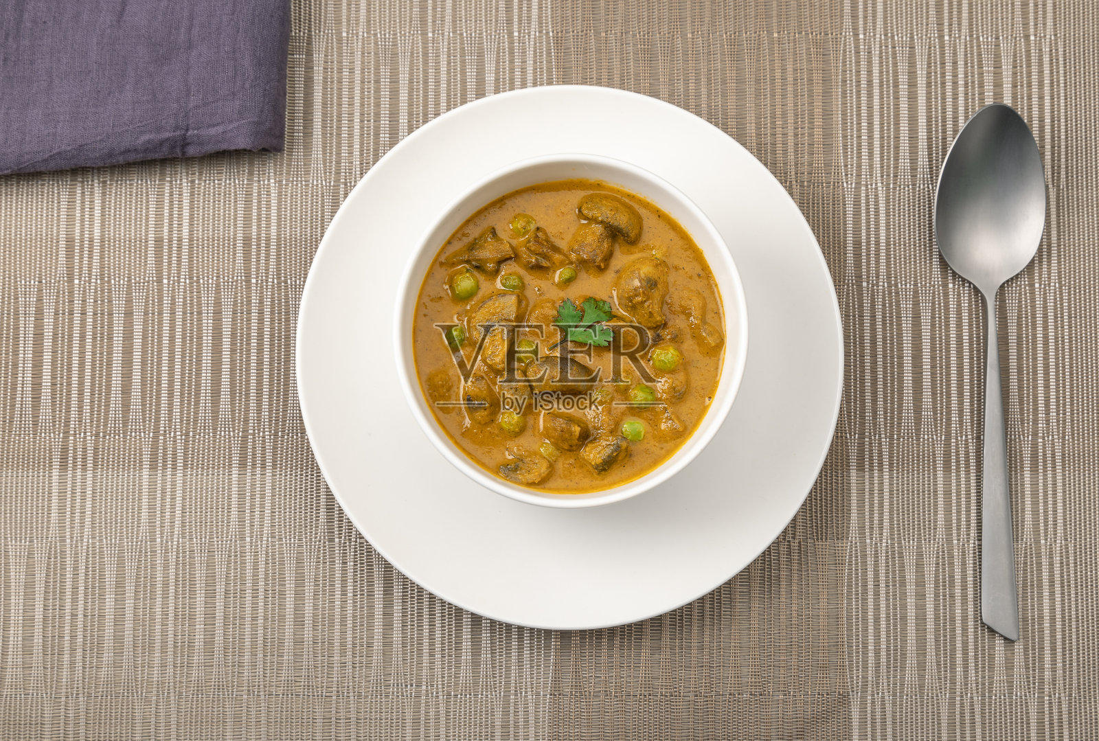 奶油豌豆和蘑菇咖喱放在一个白碗里照片摄影图片